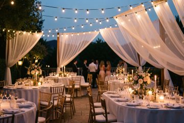 Réception en extérieur élégante à la tombée de la nuit, avec des lumières festives, tables dressées et ambiance raffinée de soirée, ambiance chaleureuse et cinématographique.